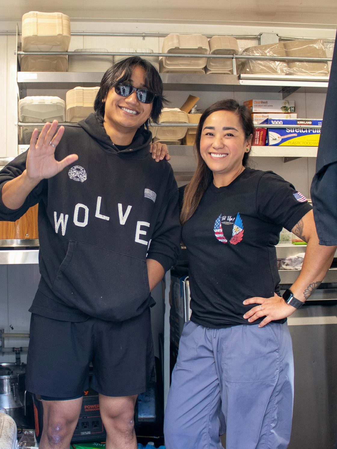 Chef Sarah and Sean (her son) inside the Fil Up! trailer in front of the service shelves