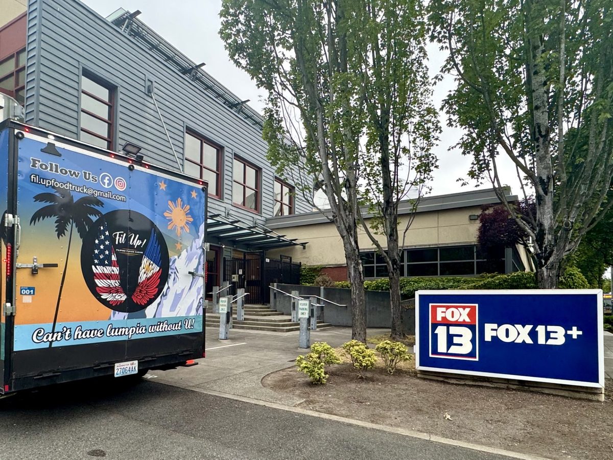 The Fil Up! trailer parked outside the FOX 13 Seattle building, next to the station’s own FOX 13+ sign